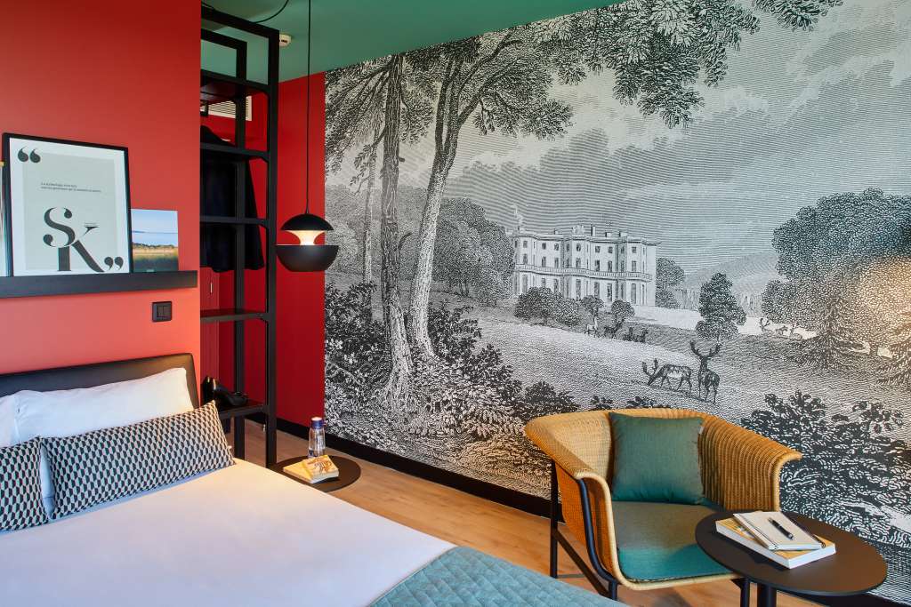 Chambre chaleureuse avec fresque murale et décoration unique, offrant tout le confort nécessaire pour un séjour agréable en séminaire.