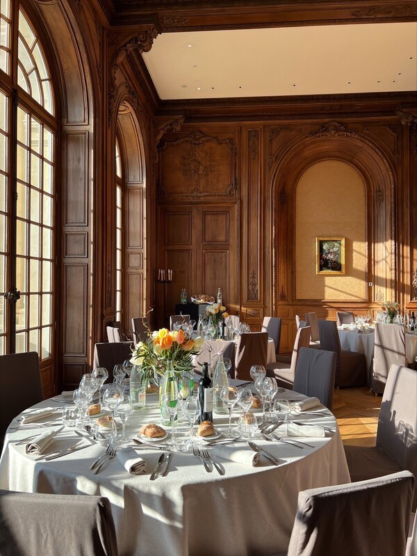 Tables élégamment dressées dans l’un des salons de réception du domaine Les Fontaines, prêtes pour accueillir un repas professionnel ou une soirée de séminaire