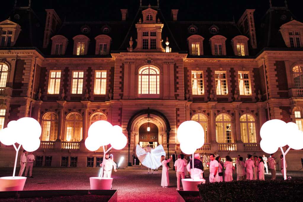 Participants rassemblés de nuit devant le domaine Les Fontaines lors d’une animation de team building